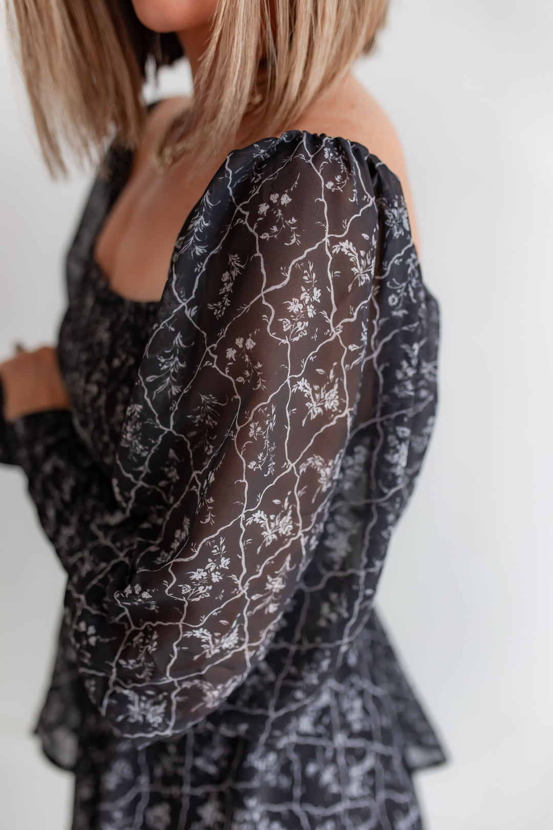 close up of sheer sleeves on a charcoal black floral maxi dress with fall print