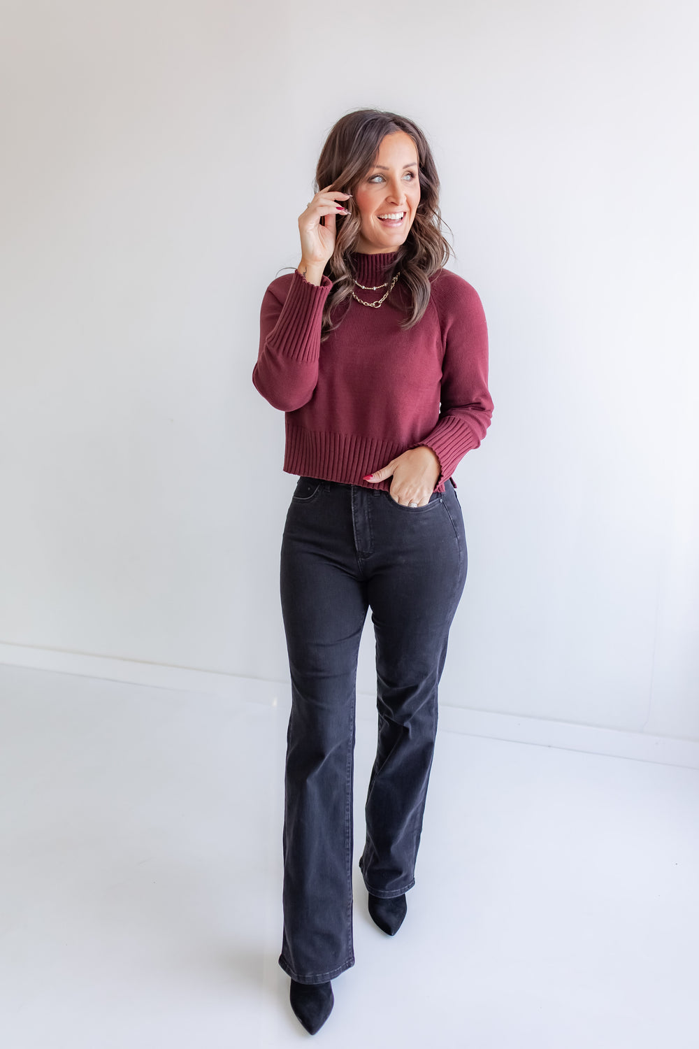 Women’s warm redwood knit turtleneck paired with black wide leg denim