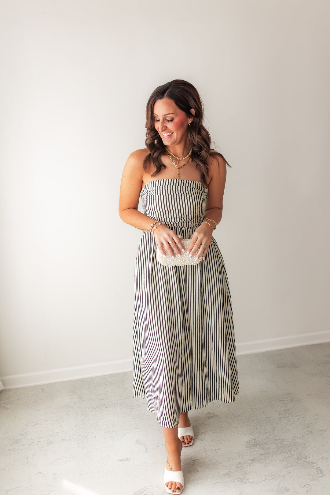 Striped strapless midi dress with smocked bodice and flowy skirt styled with sandals