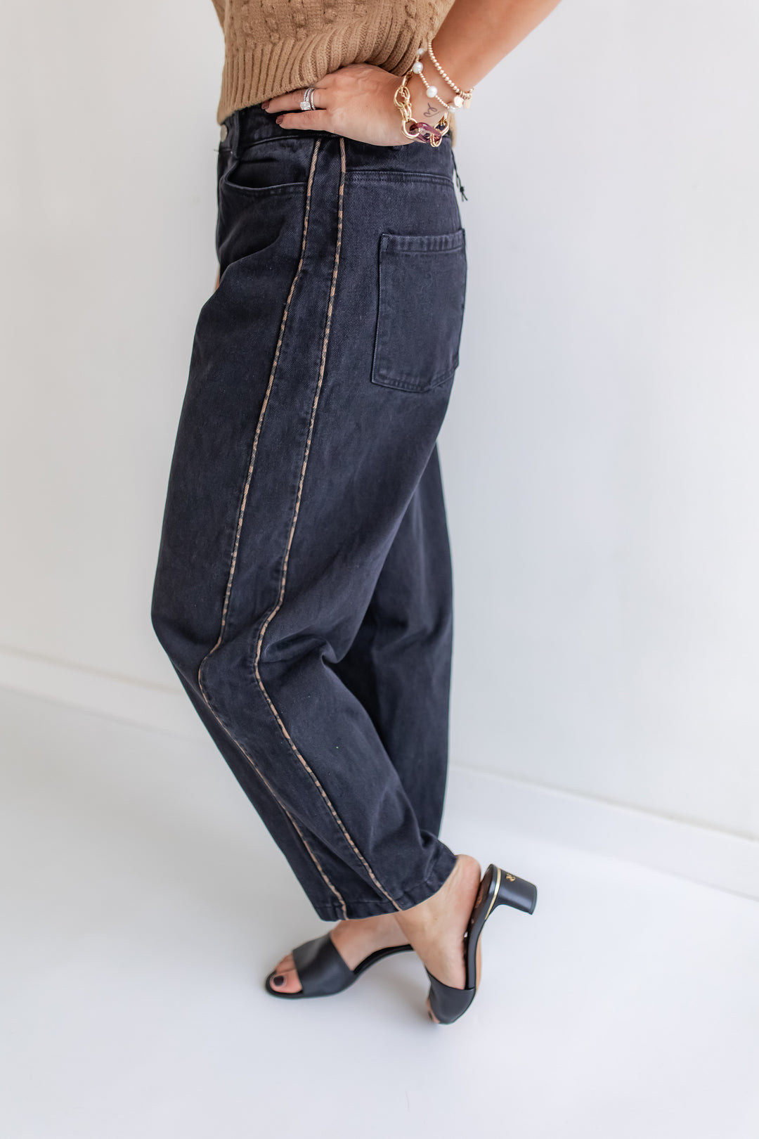 Woman wearing a pair of Black barrel jeans with leopard piping on sides