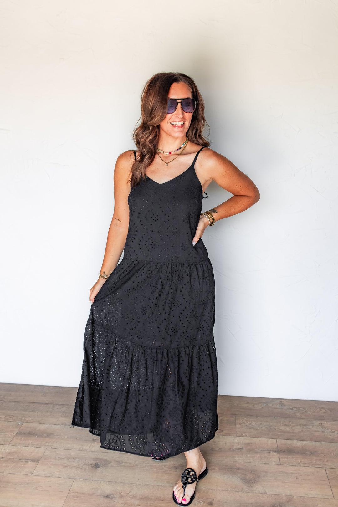 Woman wearing black eyelet tiered maxi dress with black sandals