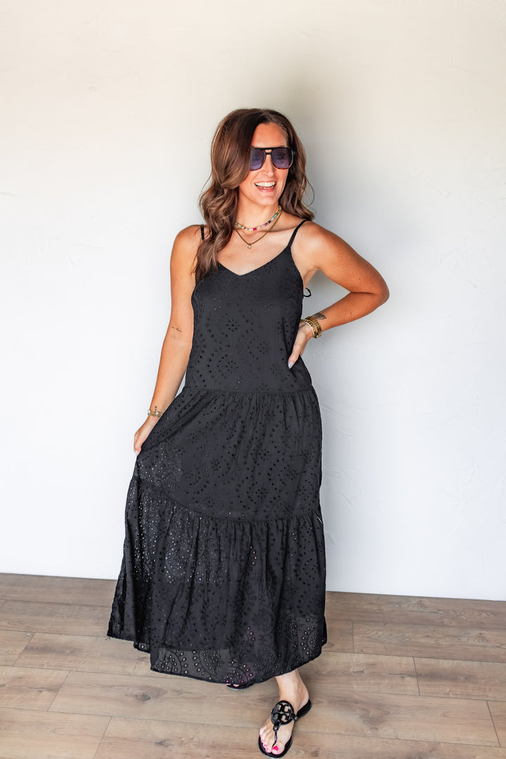 Woman wearing black eyelet tiered maxi dress with black sandals