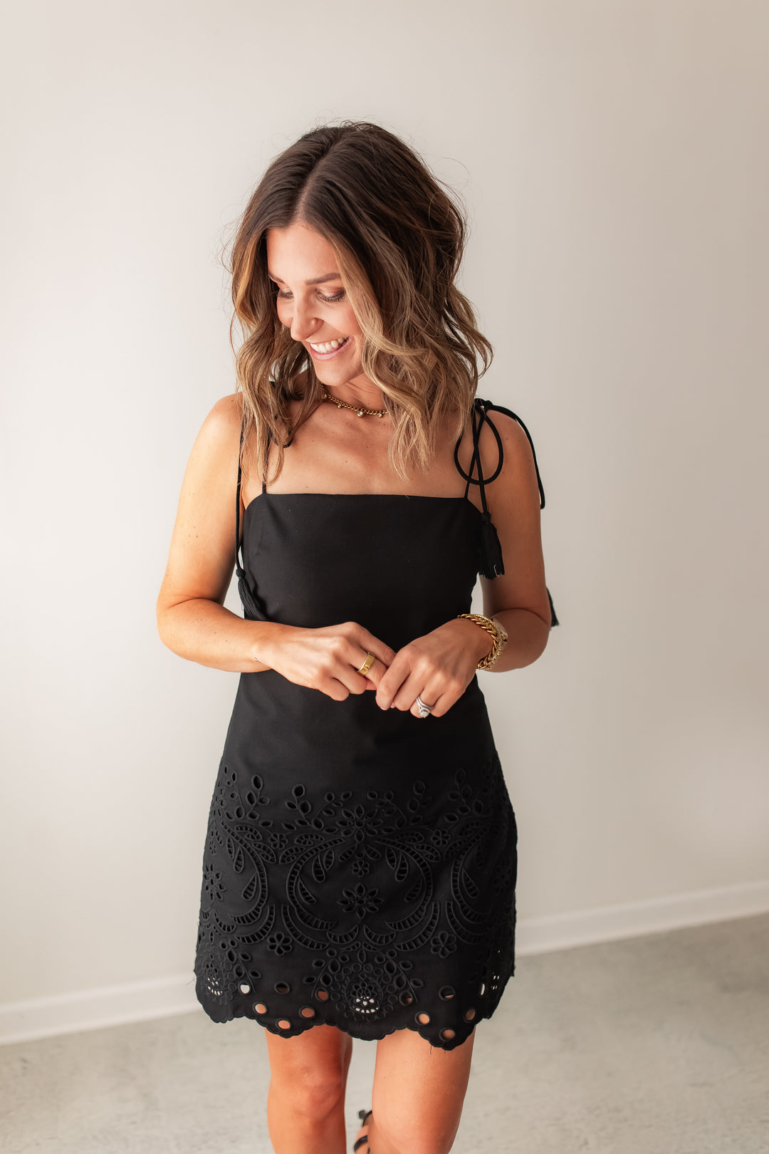 Black eyelet mini dress with adjustable tie straps with tassel and eyelet detail for a summer outfit