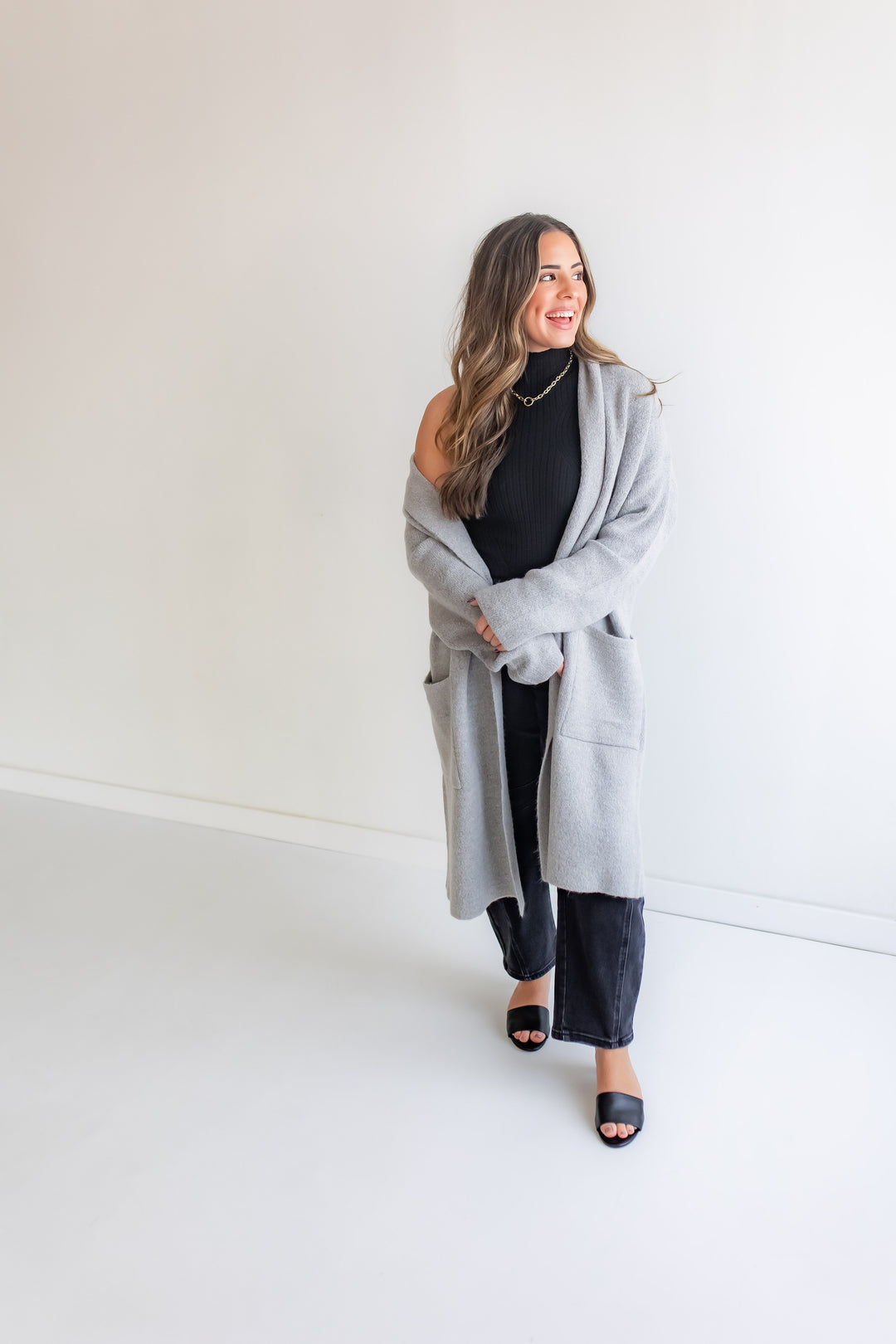 Woman wearing a gray cardigan over a black top and pants