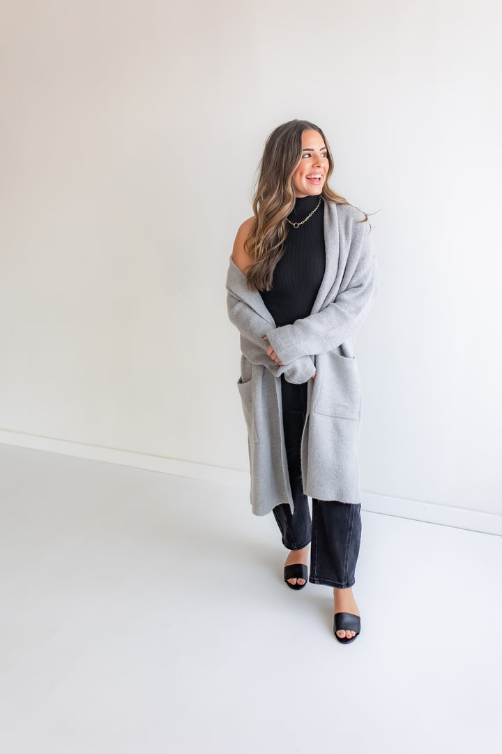 Woman wearing a gray cardigan over a black top and pants