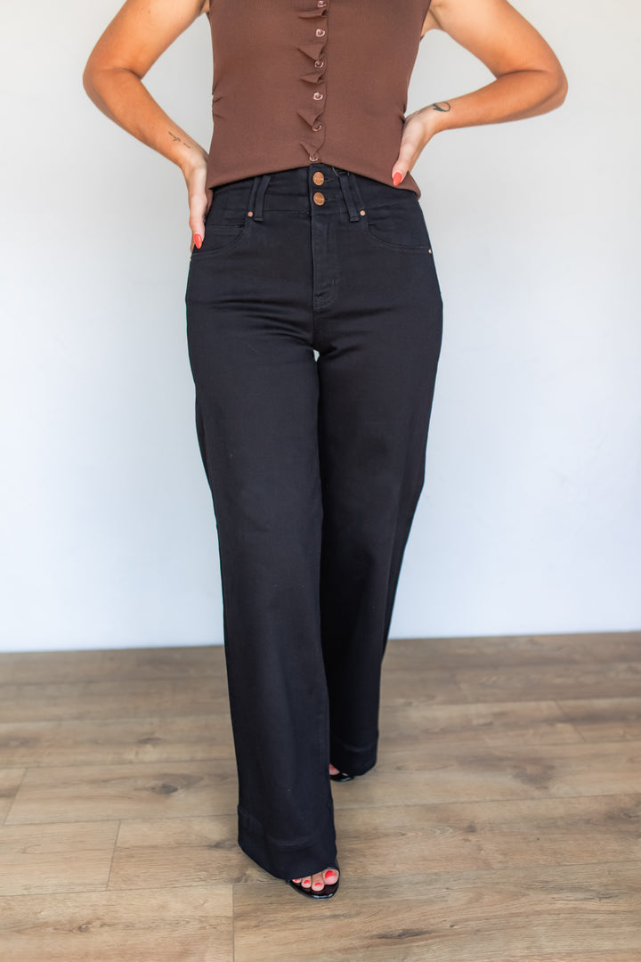 Close-up of black wide leg jeans with double button waistband detail