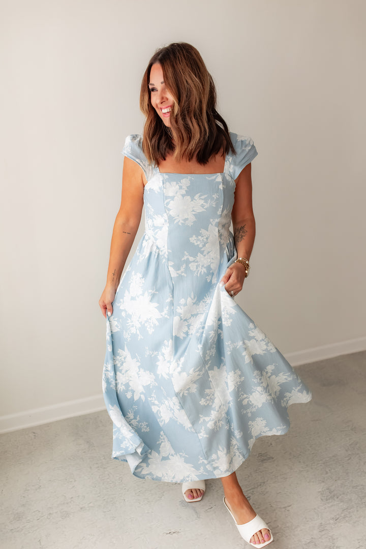A light blue floral midi dress with square neckline and flowy skirt styled with white sandals