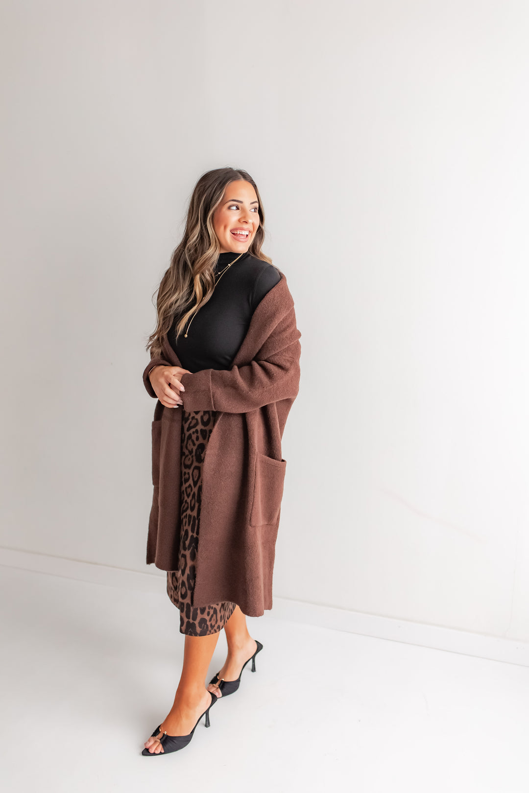 Women’s leopard front slit skirt styled with brown cardigan