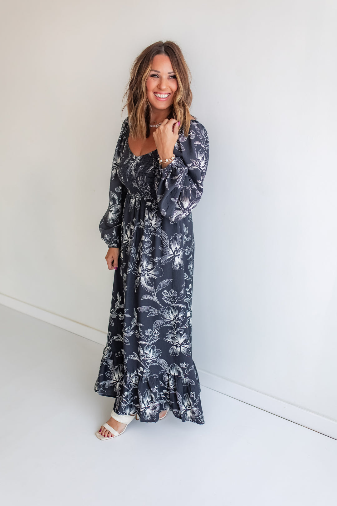 Woman wearing a long floral dress against a white background