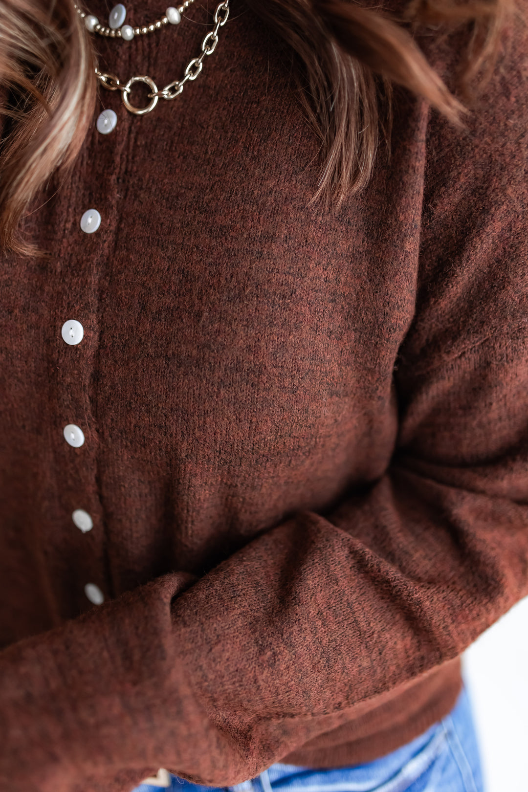 close up of a deep chocolate bown knit cardigan with front buttons