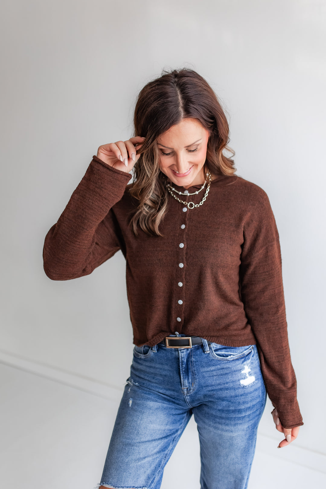 Model wearing deep chocolate brown button-up knit sweater cardigan