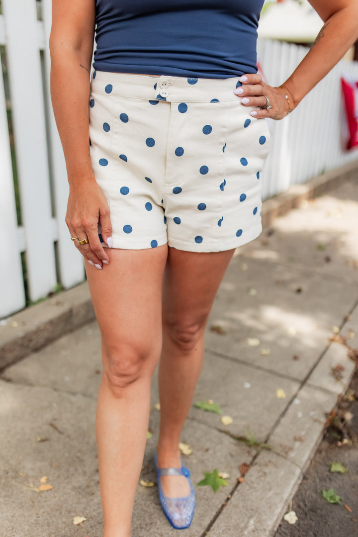 Cream shorts with navy polka dots styled with blue tank for casual summer outfit