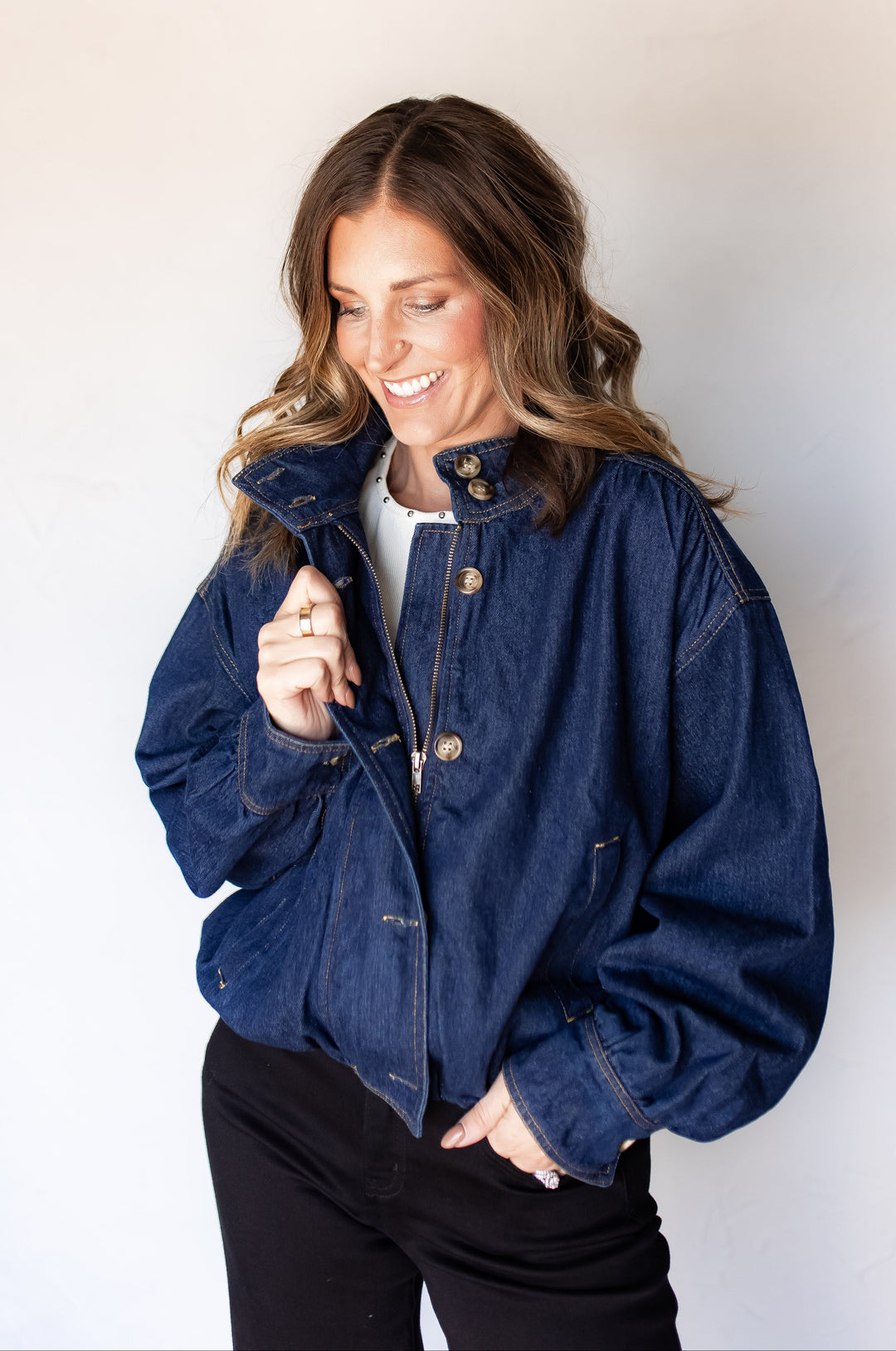 Close-up of woman wearing dark wash lined denim jacket with stand collar