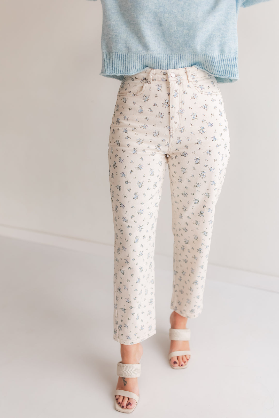 Woman wearing floral high rise straight leg jeans styled with a sweater for a spring outfit