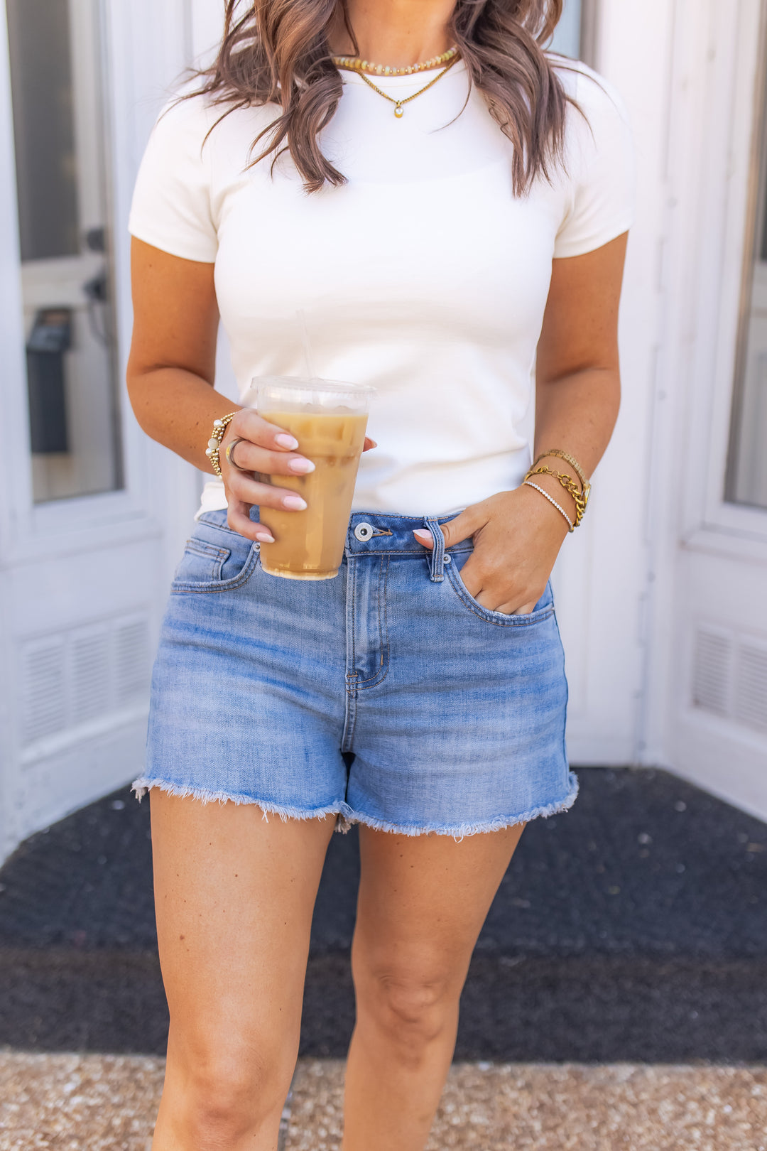 Light wash denim shorts for women styled with a white fitted top