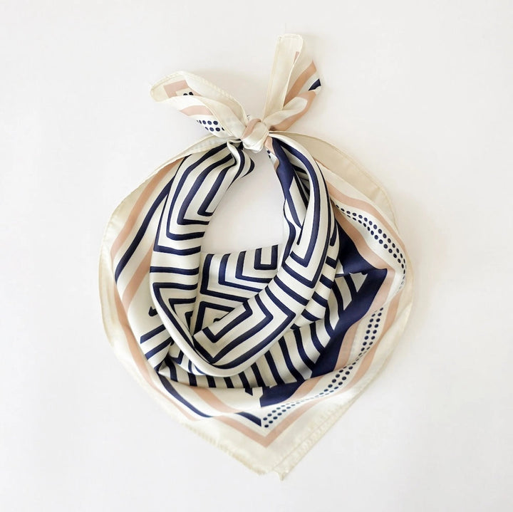 Close-up of navy and cream stripe square scarf knotted