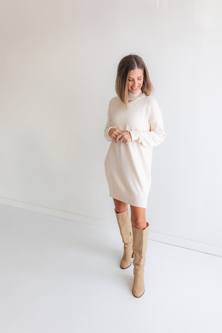 Woman wearing a white dress and beige knee-high boots