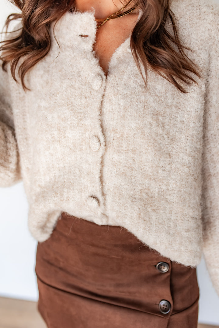 Oatmeal boxy cardigan button closeup detail with brown suede skirt