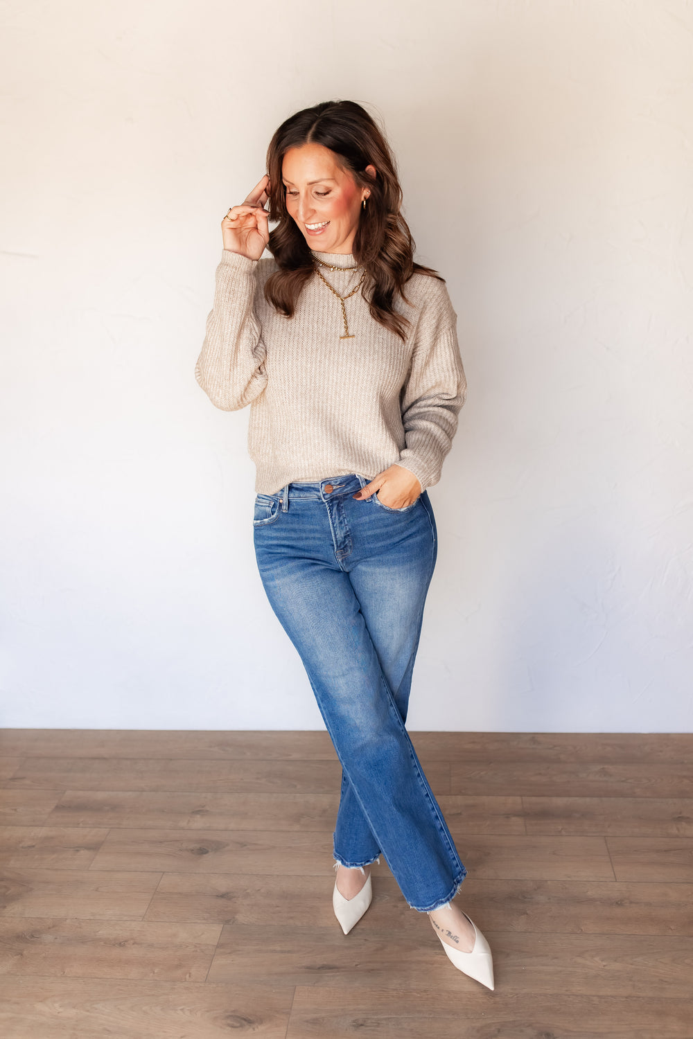 Oatmeal ribbed knit sweater styled with medium wash denim and white mules