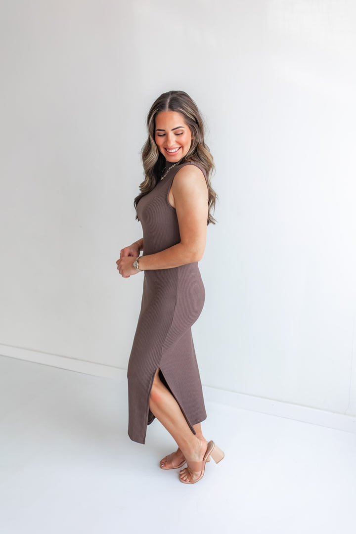 Woman wearing a brown fitted dress against a white background