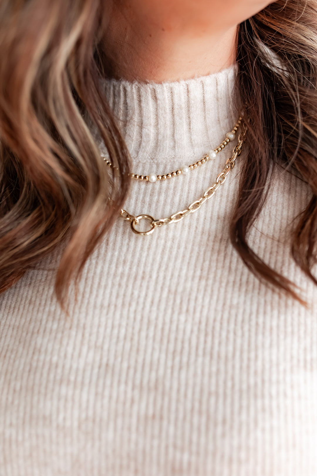 close up of a chic ivory knit sweater with black trim design