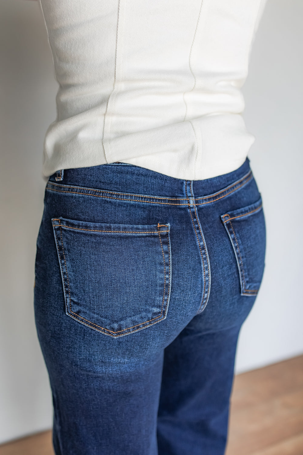 Close-up of dark wash wide leg jeans back pocket stitching detail