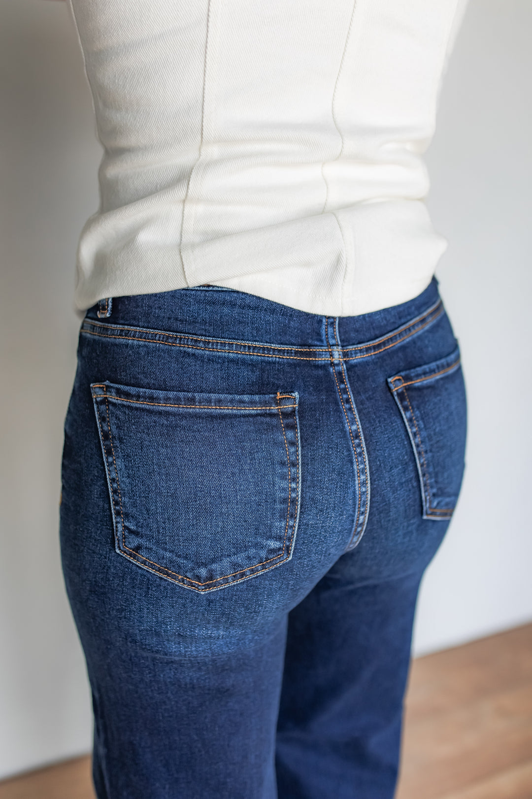 Close-up of dark wash wide leg jeans back pocket stitching detail