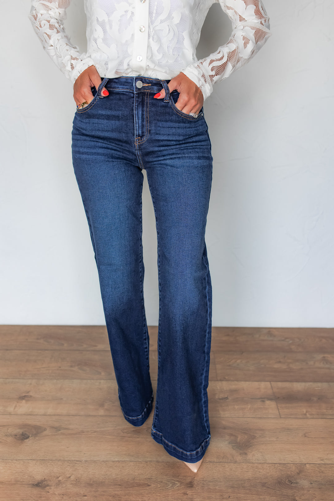 Woman wearing dark wash wide leg jeans with white lace top