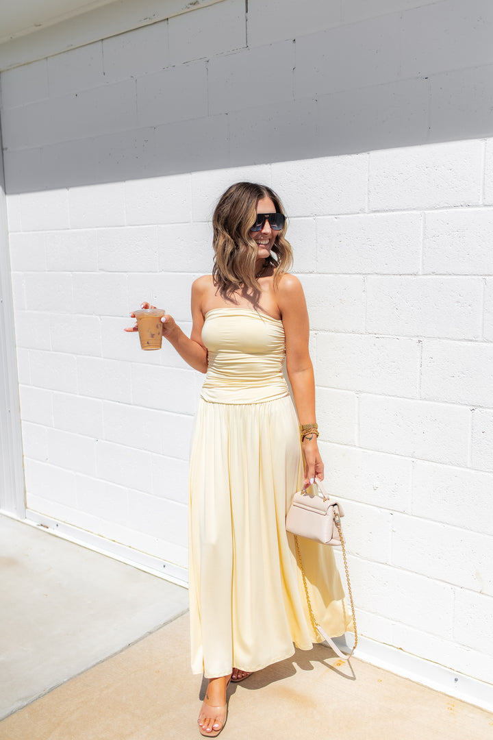 Yellow strapless maxi dress with soft fabric and flowy silhouette styled for a summer outfit